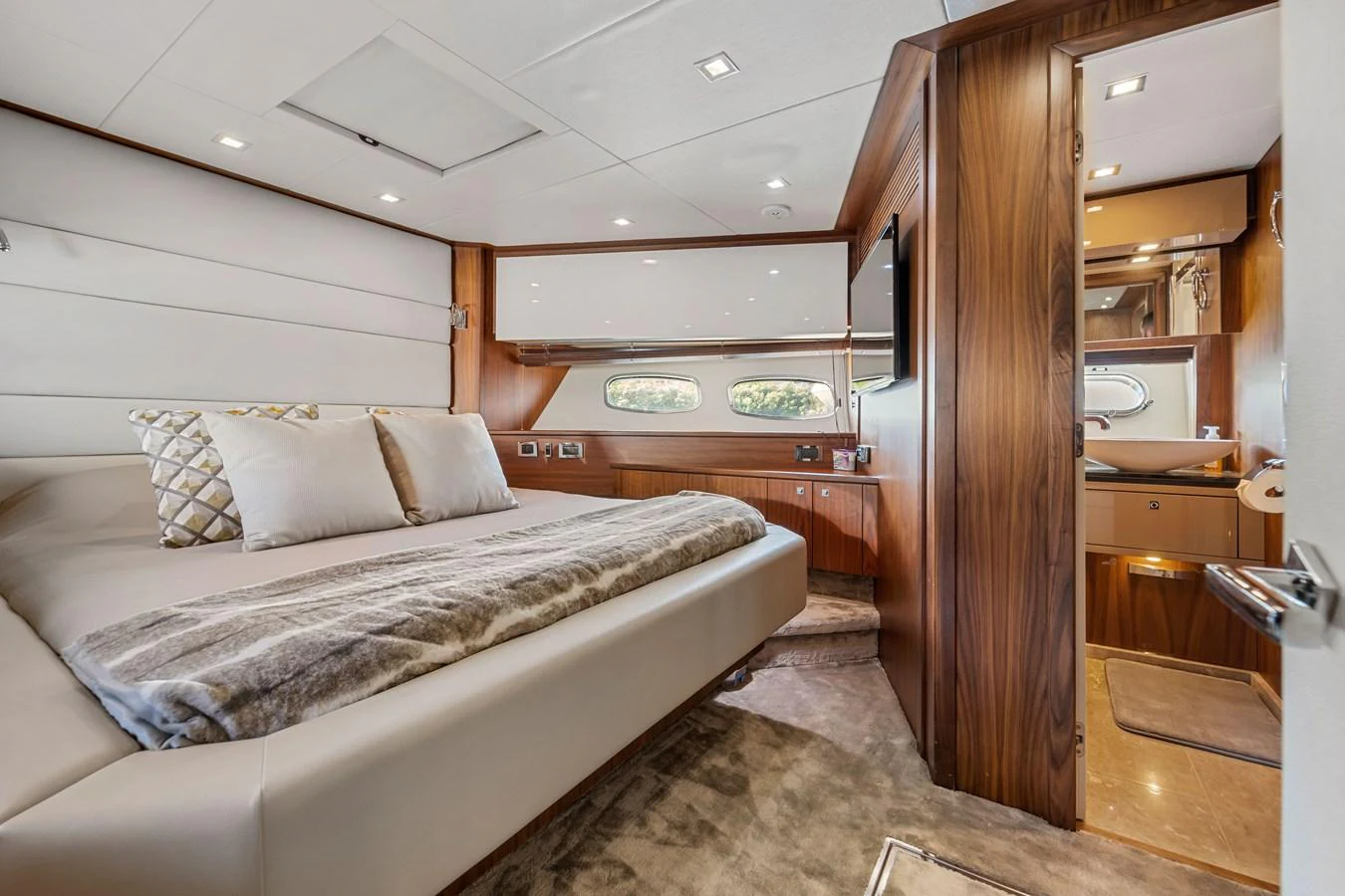 The master stateroom features a luxurious bed with plush bedding and elegant wood finishes. aboard GBXSK84PRD13 Yacht for Sale