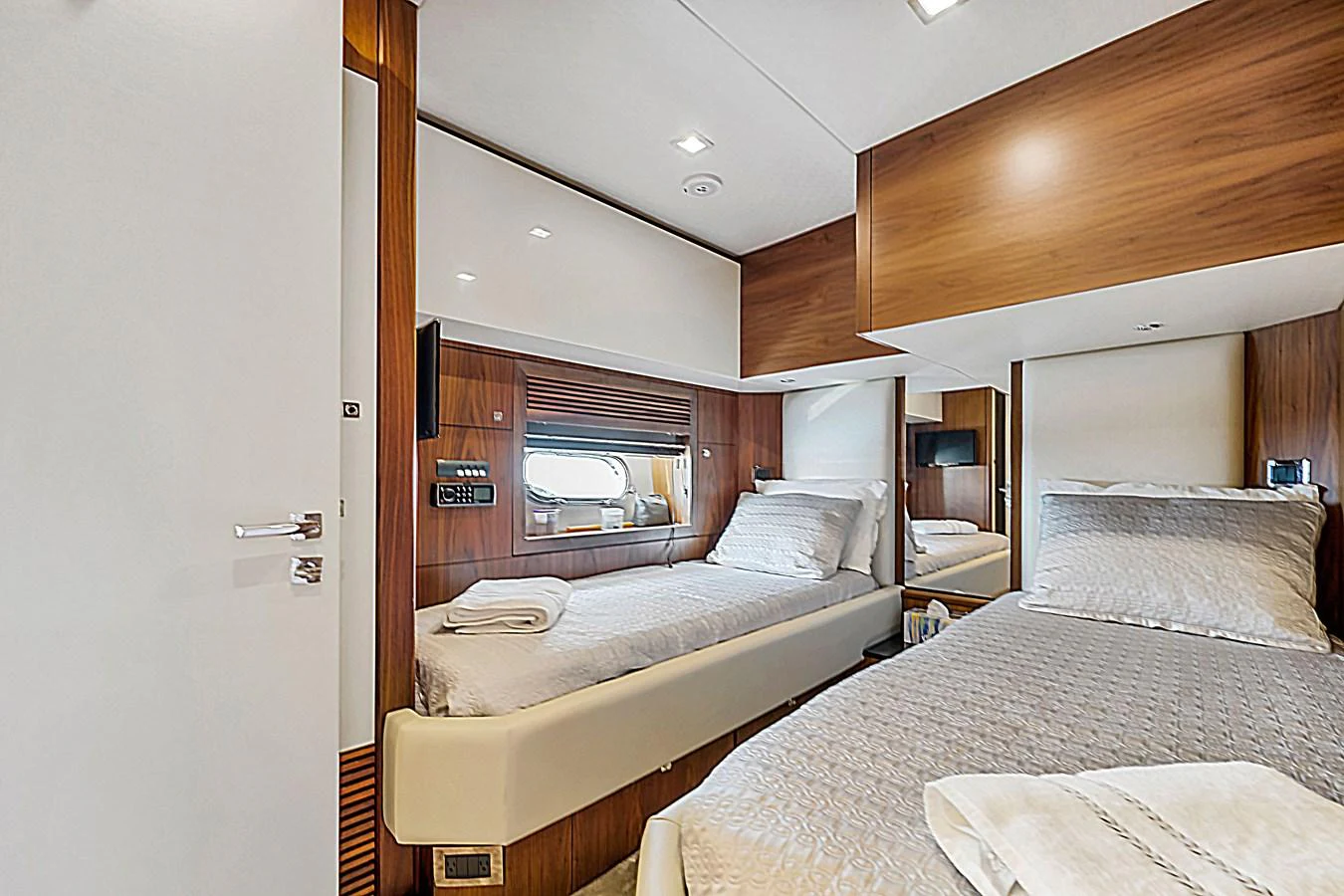 The guest stateroom features twin beds with luxurious bedding and modern wood finishes. aboard GBXSK84PRD13 Yacht for Sale