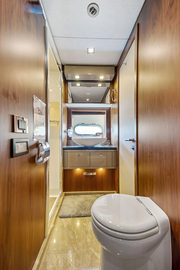 The yacht's head features elegant wood paneling and modern fixtures, creating a luxurious and comfortable space. aboard GBXSK84PRD13 Yacht for Sale
