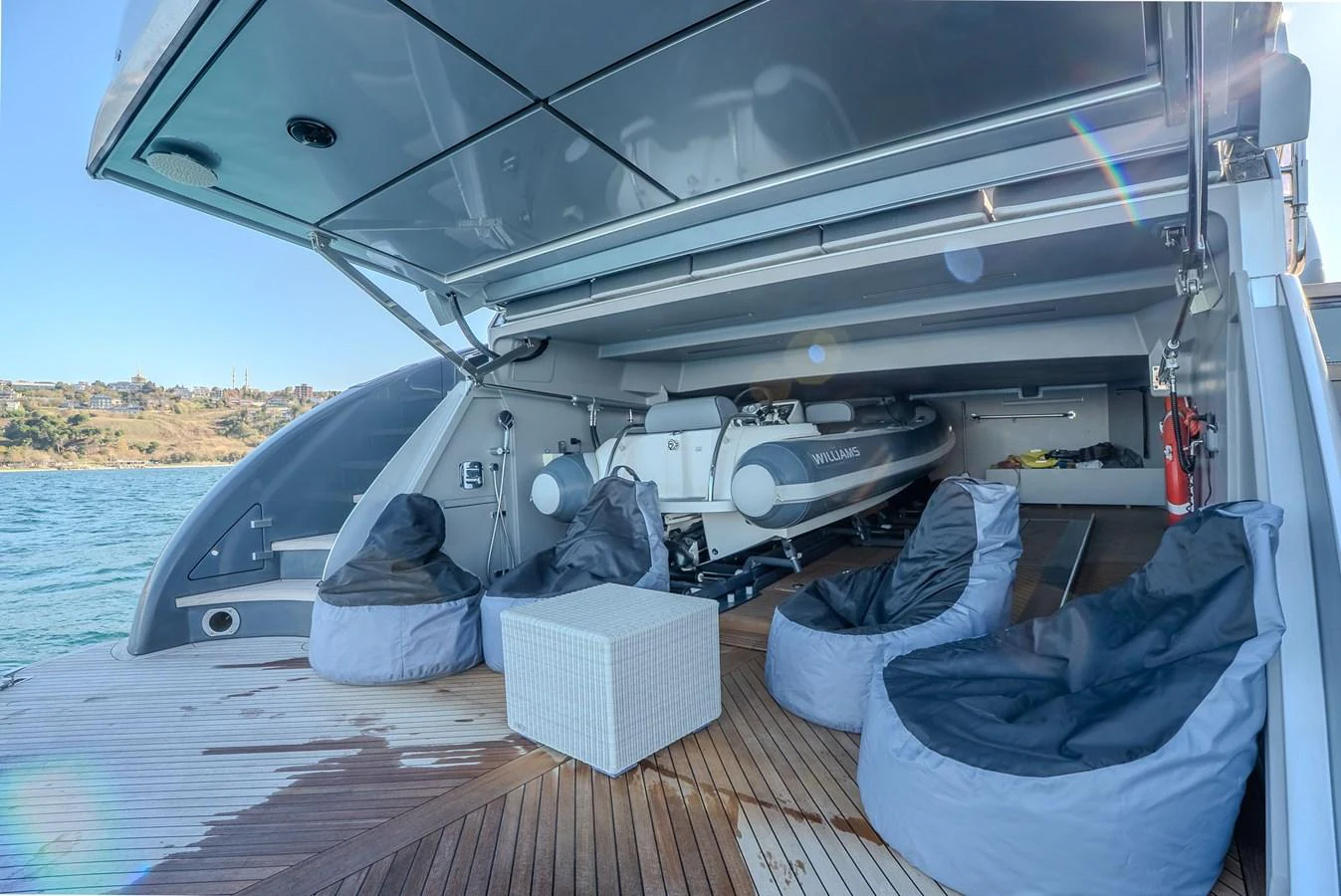 The aft deck features comfortable seating with bean bags and a tender storage area. aboard SPECTRE Yacht for Sale