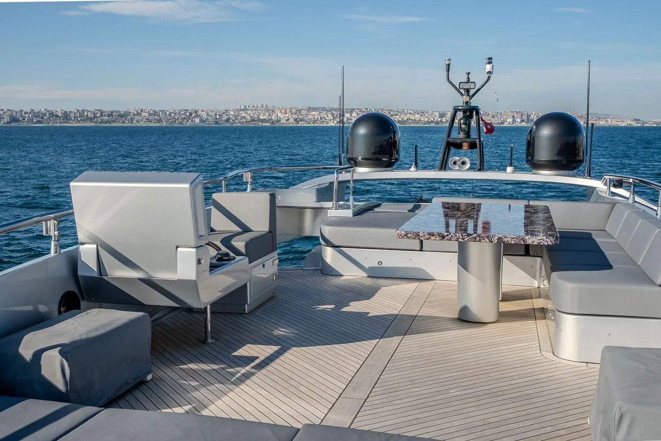 The flybridge offers a spacious seating area with a sleek table, perfect for enjoying panoramic ocean views. aboard SPECTRE Yacht for Sale
