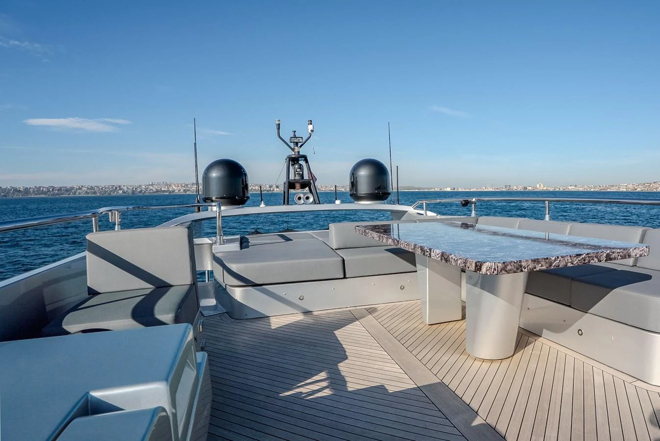 The flybridge offers a spacious seating area with a sleek table, perfect for enjoying panoramic ocean views. aboard SPECTRE Yacht for Sale