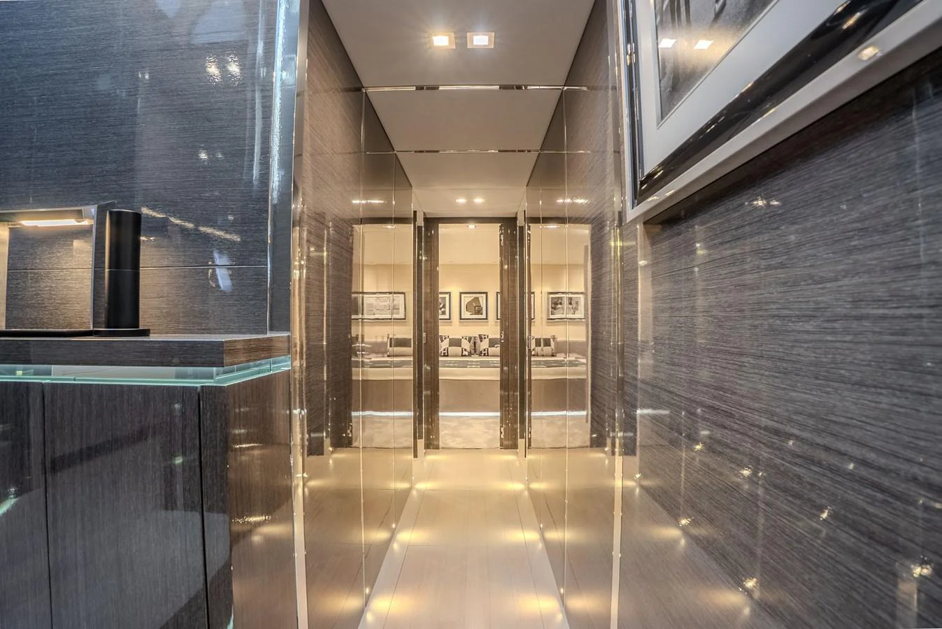 A sleek and modern hallway with reflective surfaces and ambient lighting. aboard SPECTRE Yacht for Sale