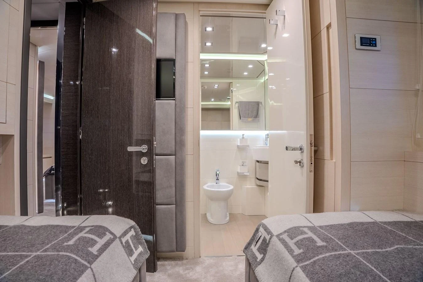 The guest cabin features twin beds and an en-suite bathroom with modern fixtures. aboard SPECTRE Yacht for Sale