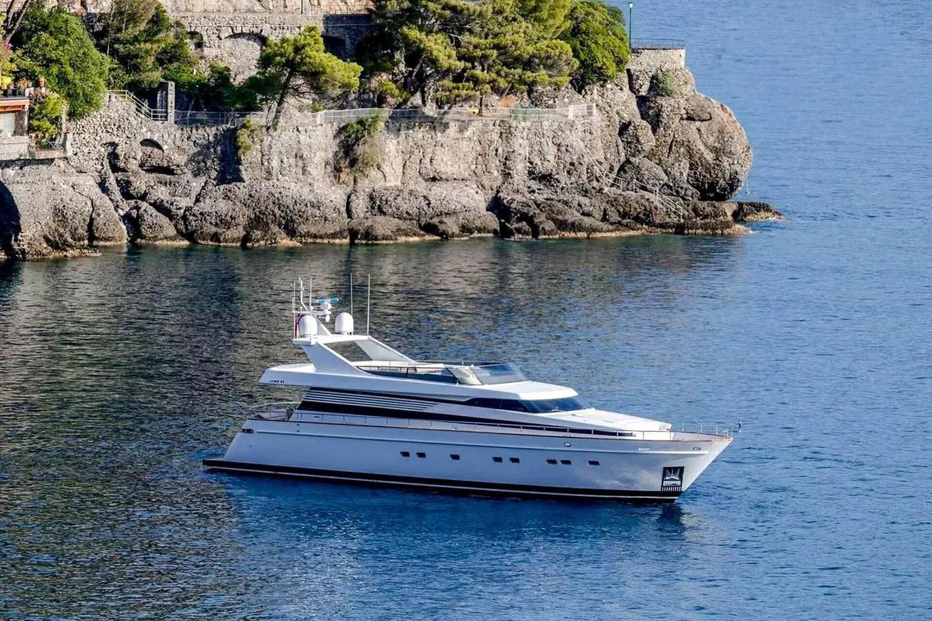 A sleek yacht cruises along a rocky coastline, showcasing its modern design and luxurious appeal. aboard GALINI Yacht for Sale