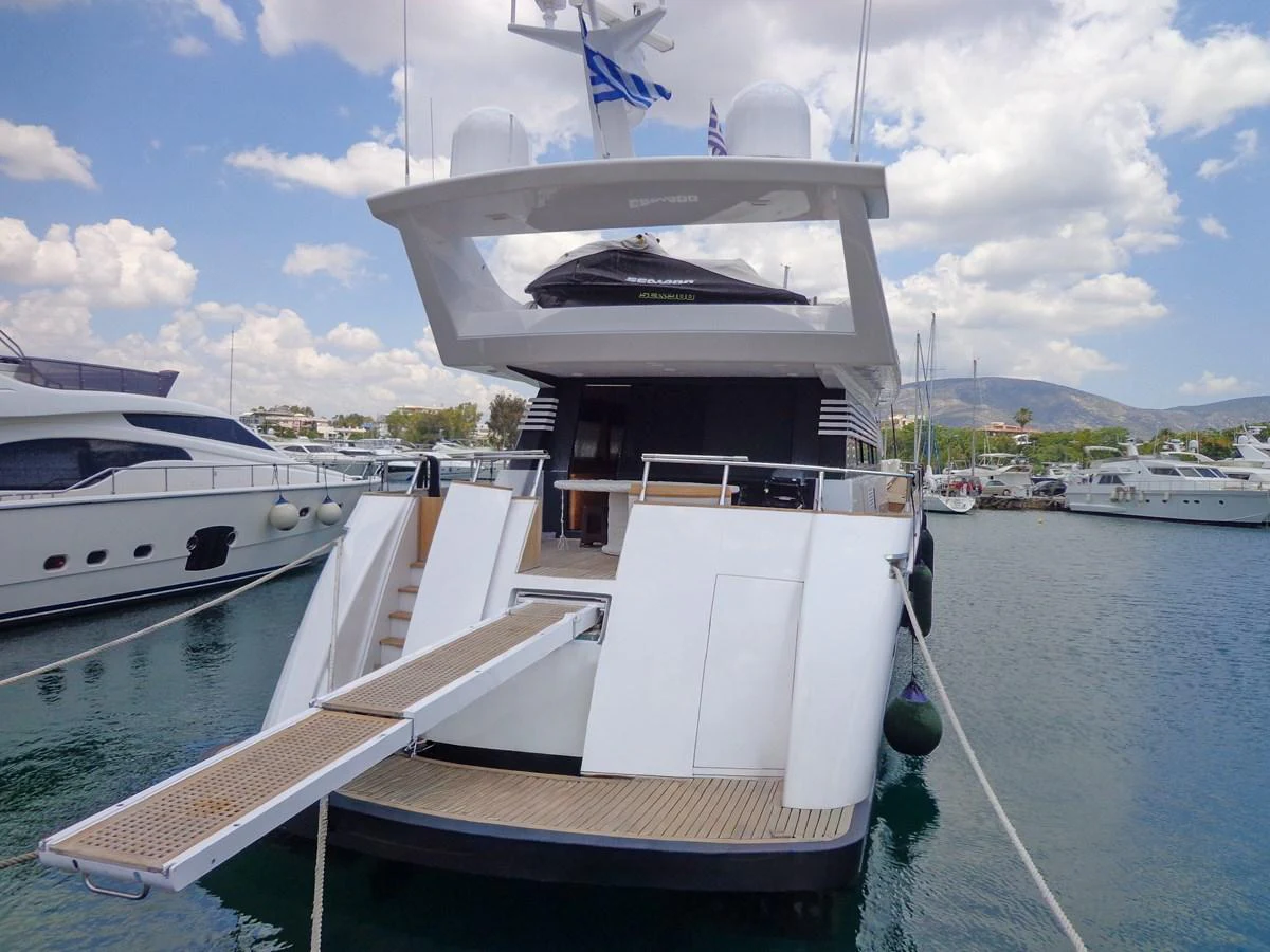 The yacht is docked at a marina with its aft deck and boarding ramp visible. aboard GALINI Yacht for Sale