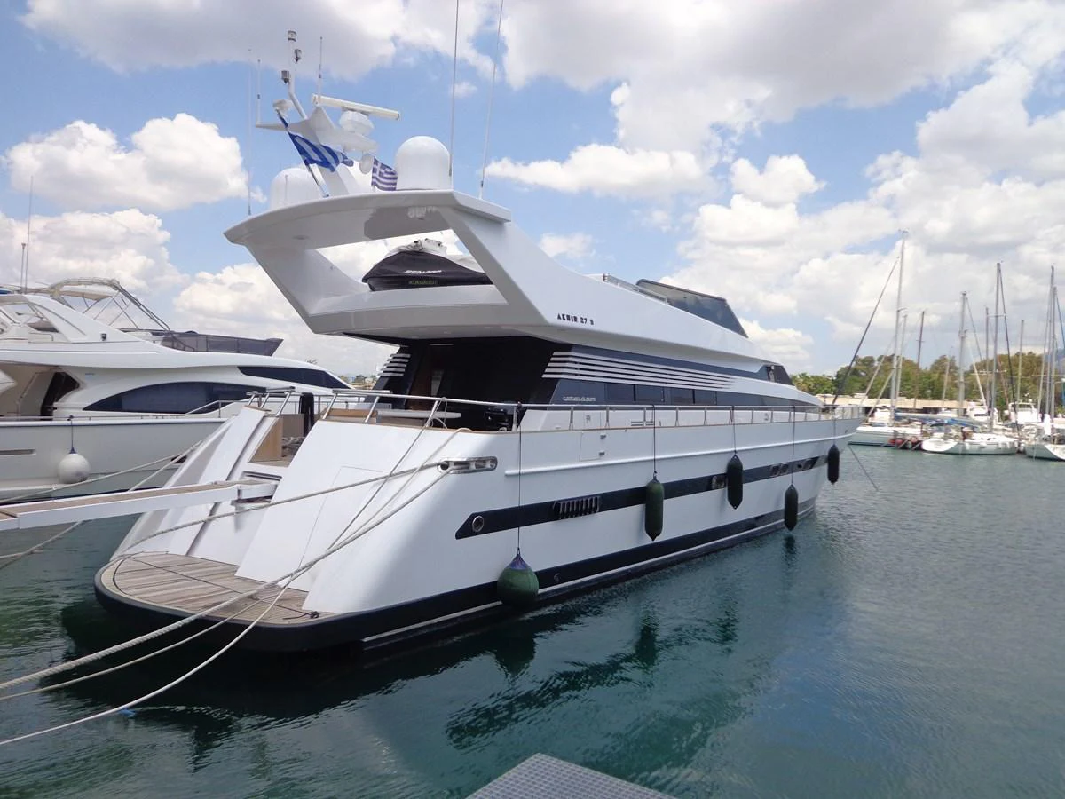 A sleek, modern yacht docked at a marina under a partly cloudy sky. aboard GALINI Yacht for Sale