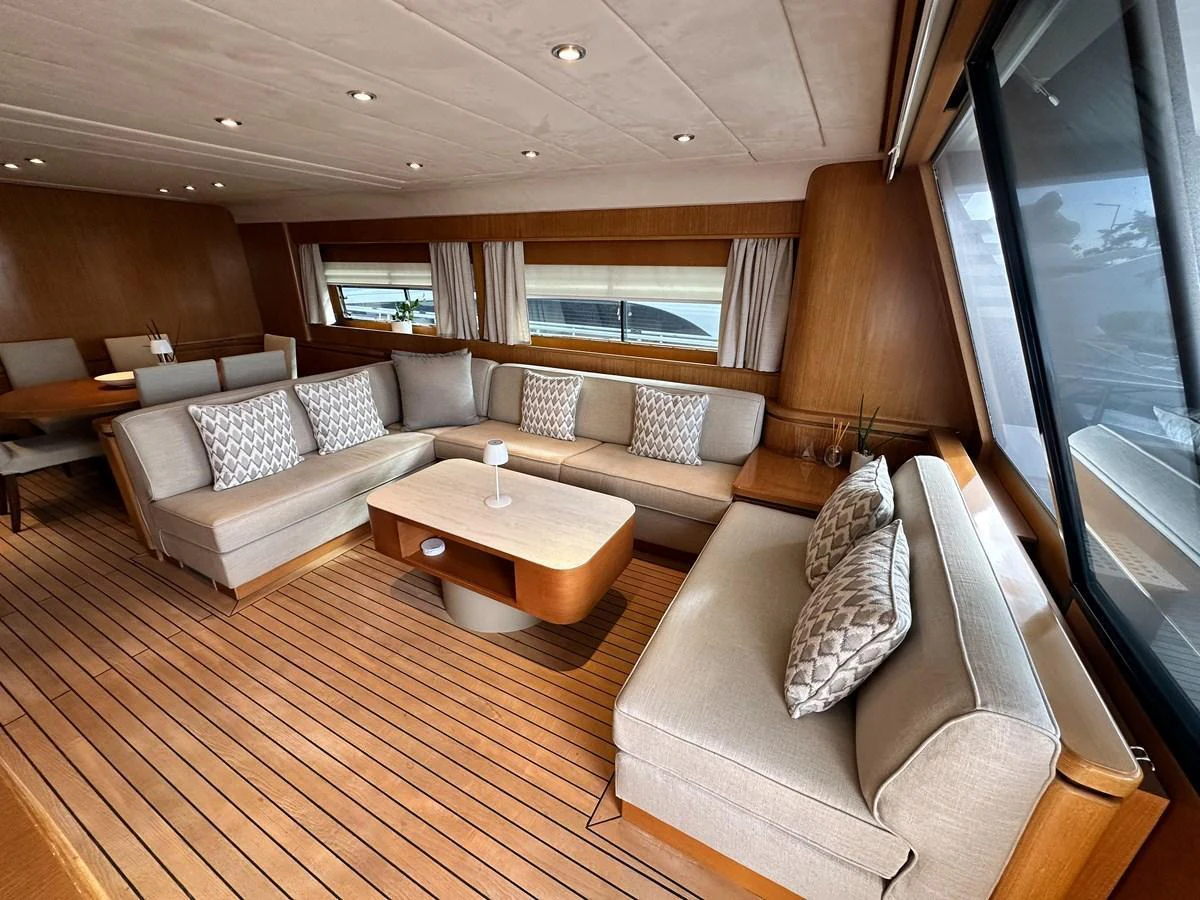 The salon features plush seating and large windows, creating a comfortable and inviting space for relaxation. aboard GALINI Yacht for Sale