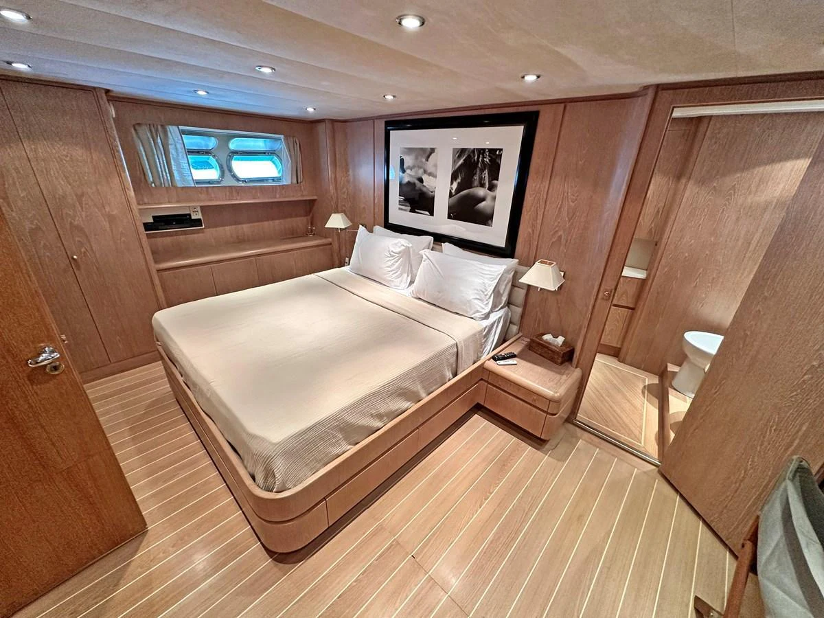 The master stateroom features a spacious bed, elegant wood paneling, and ample natural light. aboard GALINI Yacht for Sale