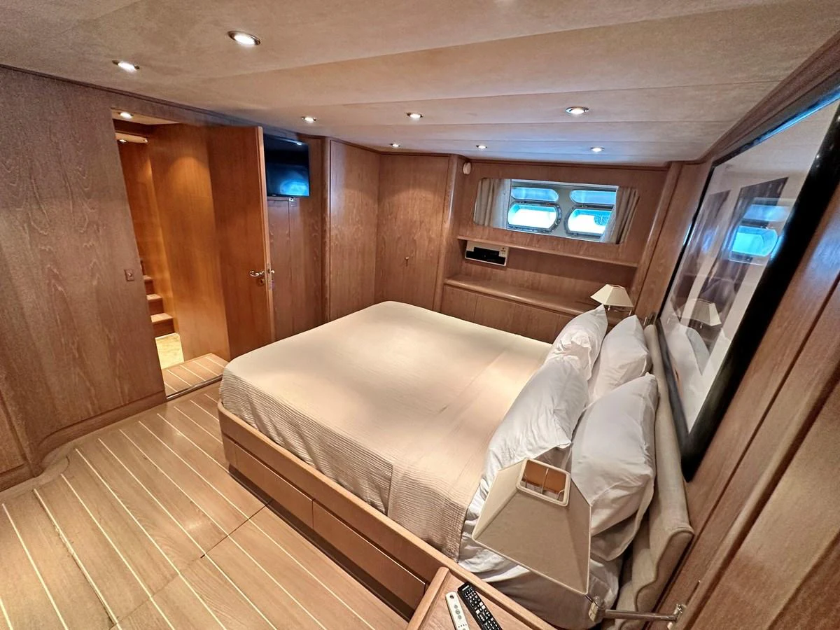 A cozy and elegantly designed stateroom with a comfortable bed and warm lighting. aboard GALINI Yacht for Sale