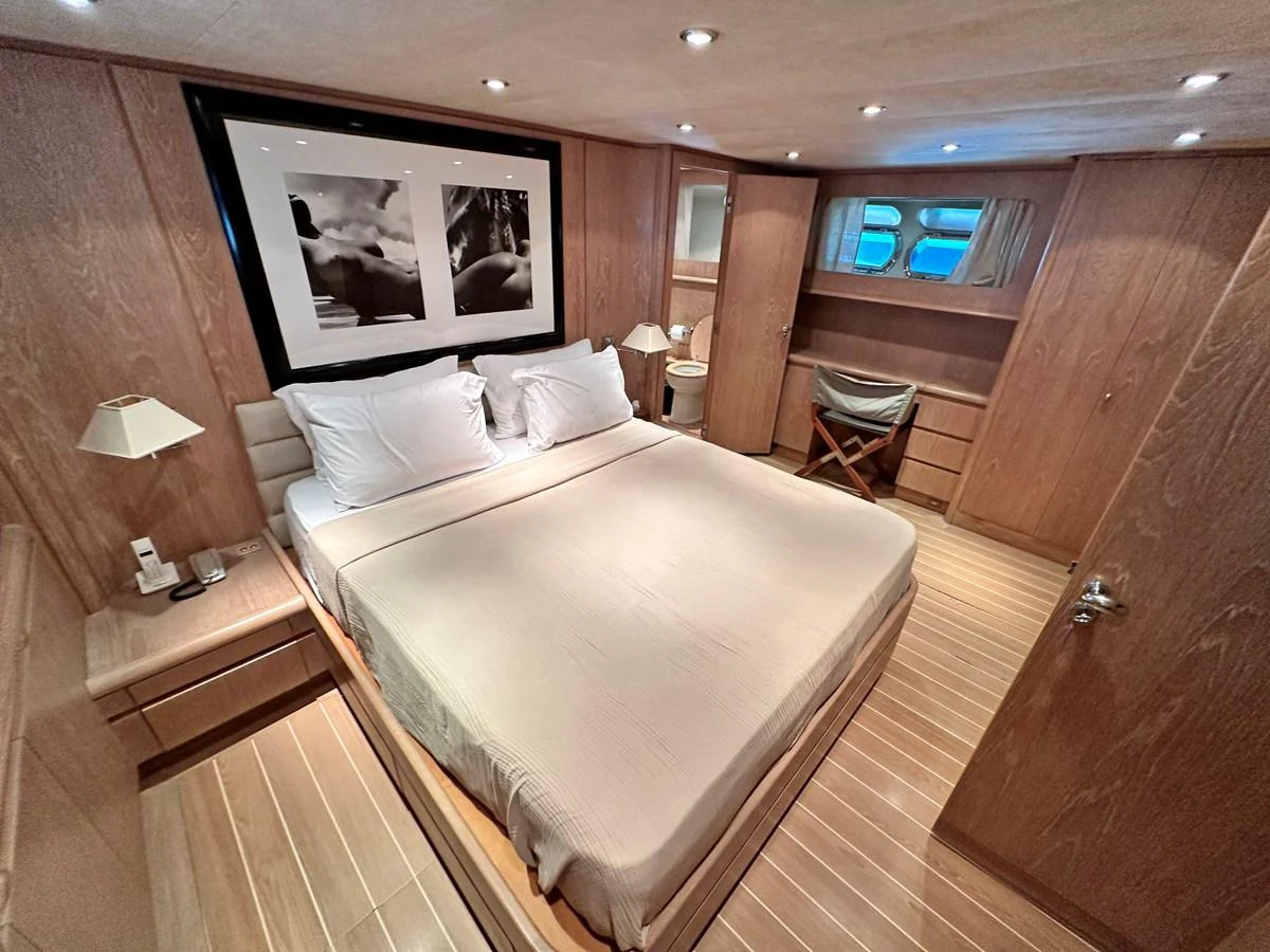 The master stateroom features a spacious bed with elegant wood paneling and modern decor. aboard GALINI Yacht for Sale