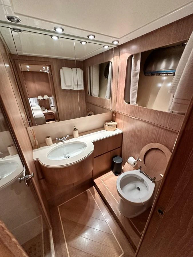 The yacht's bathroom features elegant wood paneling and modern fixtures, creating a warm and inviting space. aboard GALINI Yacht for Sale