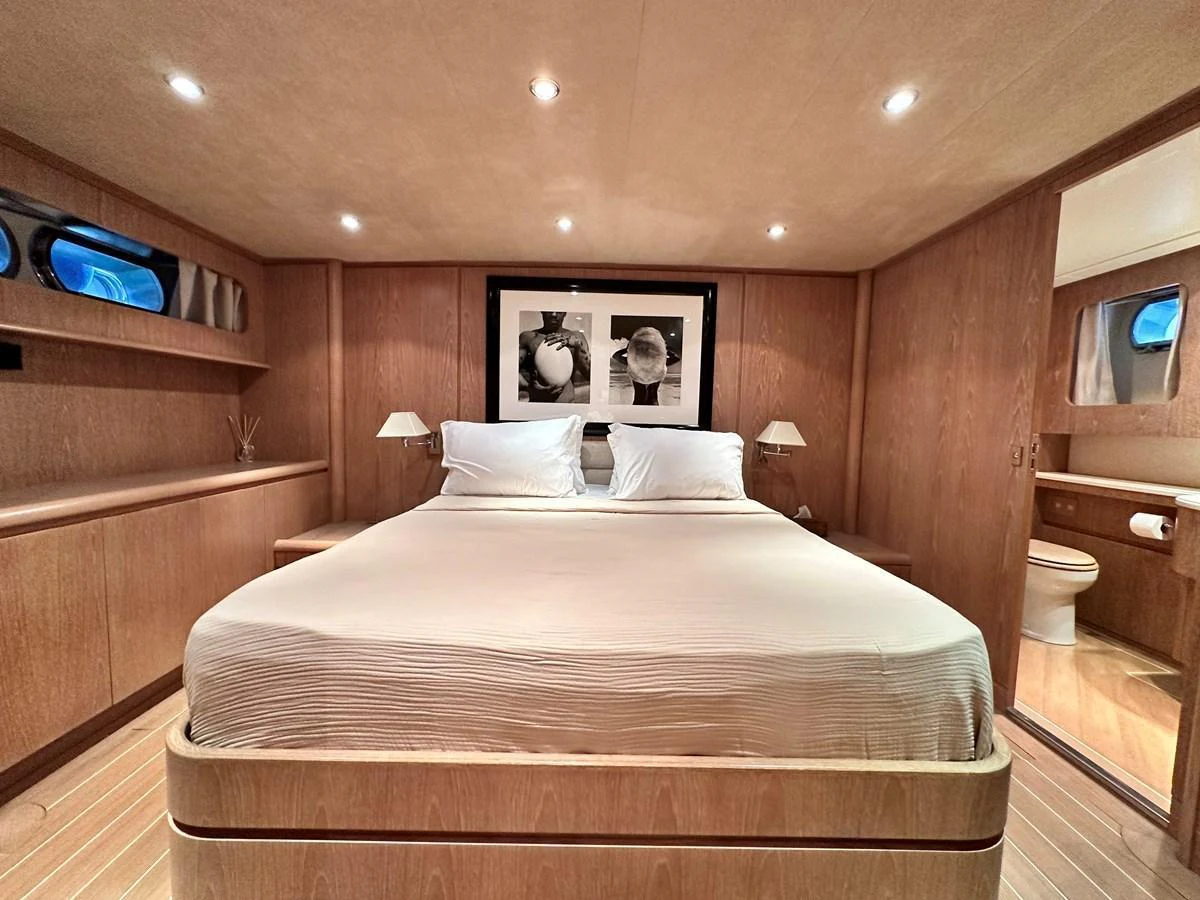 The master stateroom features a spacious bed with elegant wood paneling and soft lighting. aboard GALINI Yacht for Sale