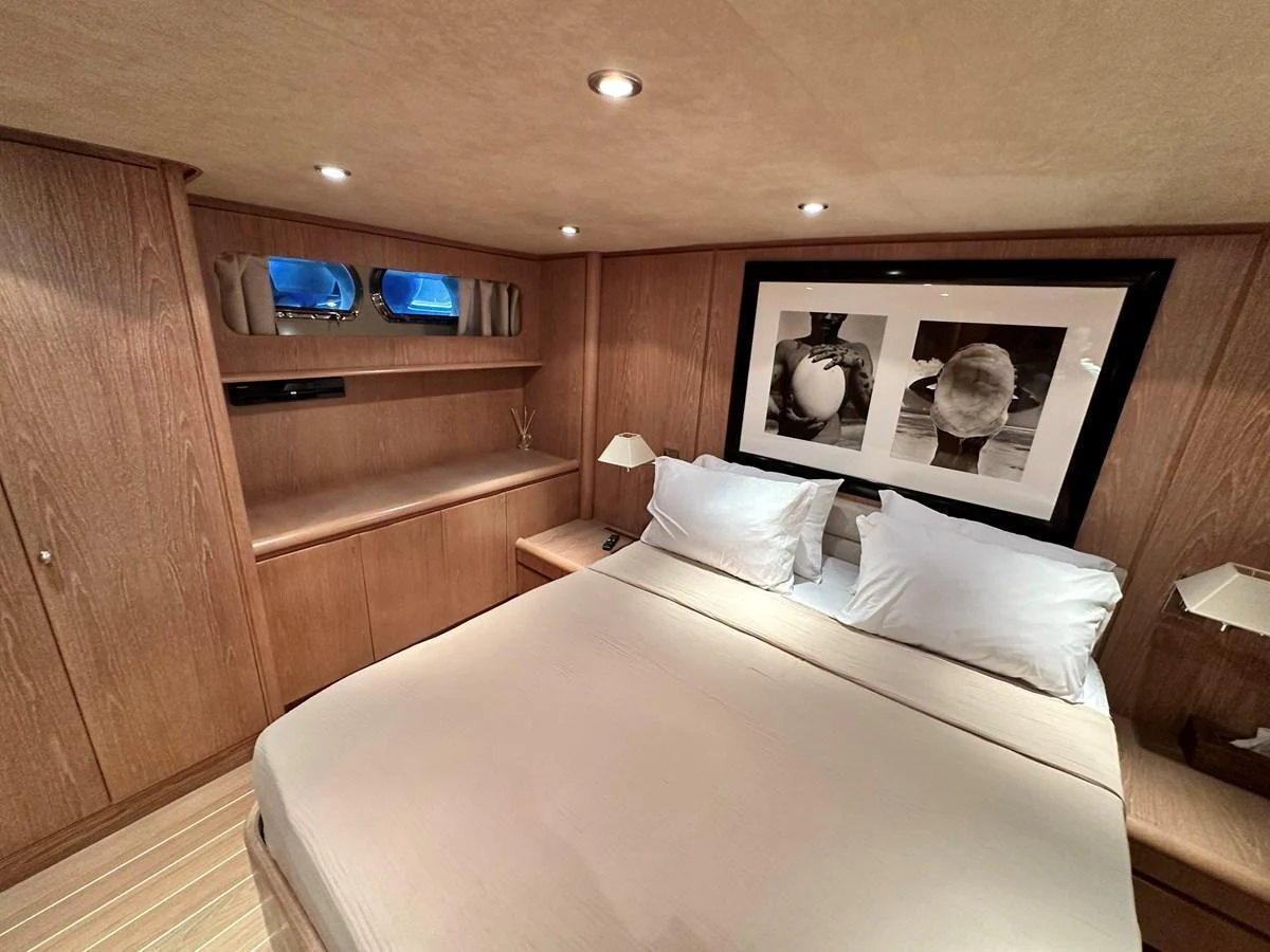 A cozy stateroom featuring a double bed and elegant wooden cabinetry. aboard GALINI Yacht for Sale