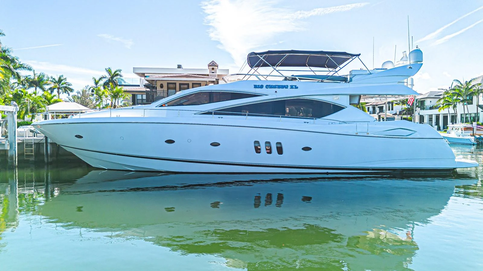 A sleek and modern yacht is docked in a serene marina, showcasing its elegant lines and luxurious design. aboard BIG CHUBBY XL Yacht for Sale