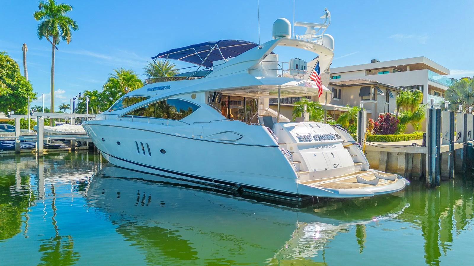 A sleek and modern yacht docked in a serene marina, showcasing its elegant design and spacious aft deck. aboard BIG CHUBBY XL Yacht for Sale