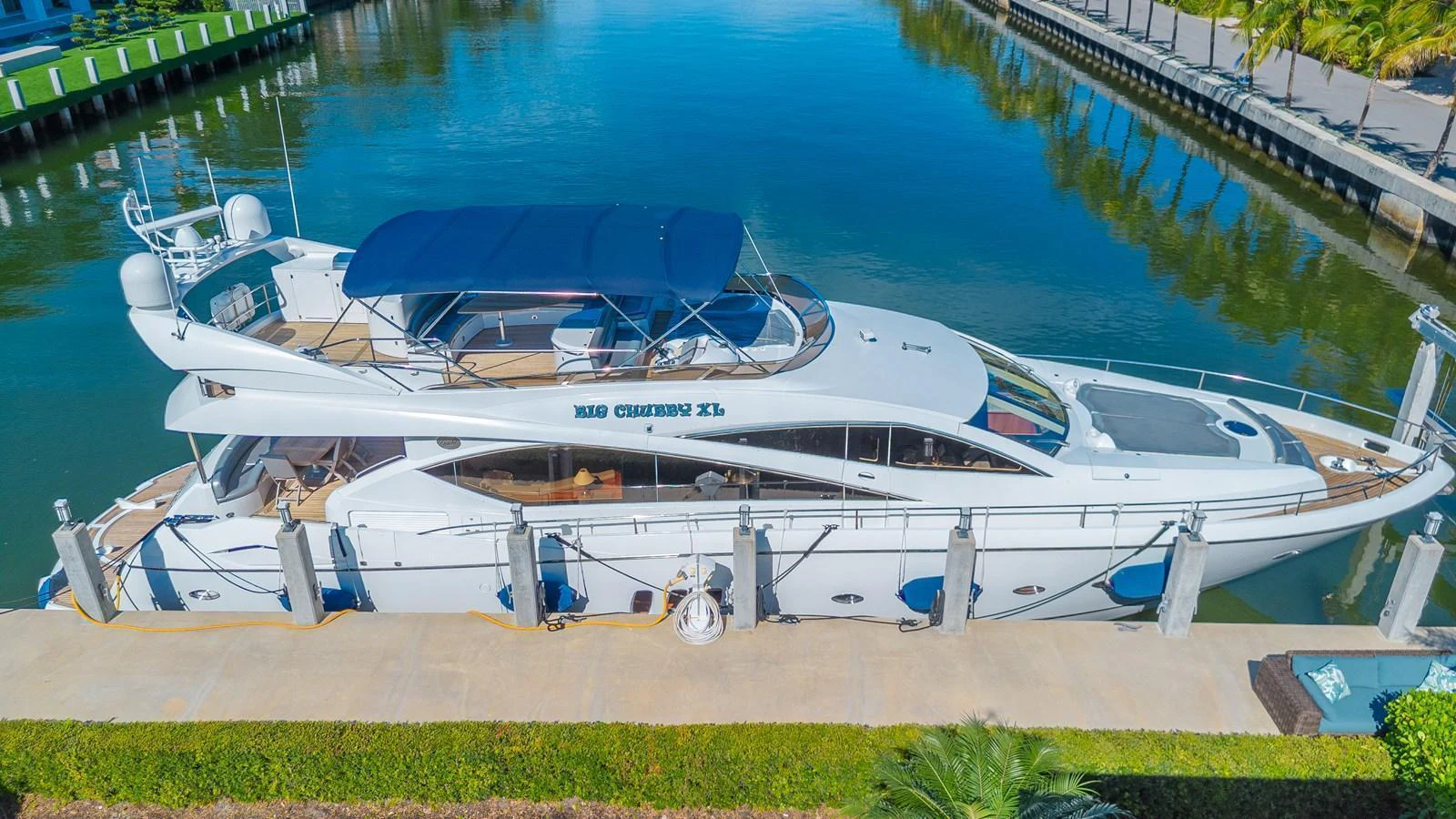 A sleek yacht is docked at a serene marina, showcasing its elegant design and spacious decks. aboard BIG CHUBBY XL Yacht for Sale