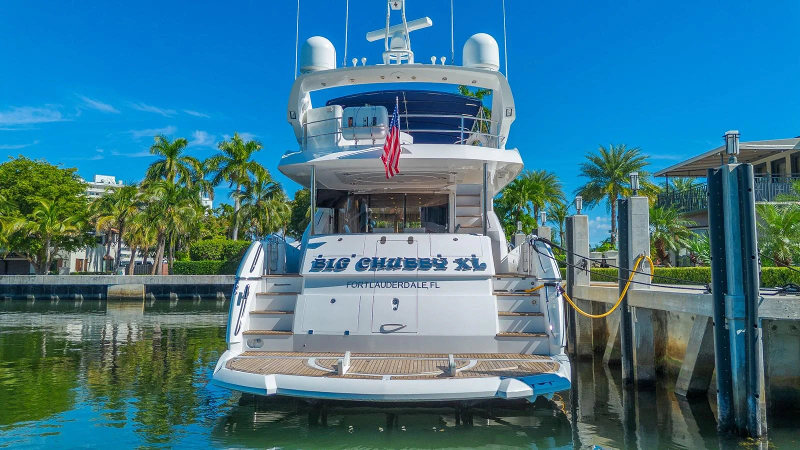 The yacht is docked at a marina, showcasing its spacious stern and inviting outdoor areas. aboard BIG CHUBBY XL Yacht for Sale