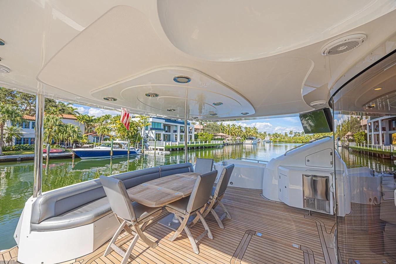 The aft deck features a spacious seating area with a dining table, perfect for enjoying meals with a view of the water. aboard BIG CHUBBY XL Yacht for Sale
