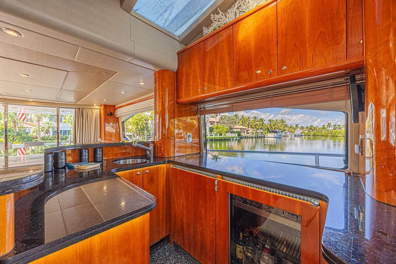 The galley features sleek wooden cabinetry and expansive windows offering a scenic view. aboard BIG CHUBBY XL Yacht for Sale