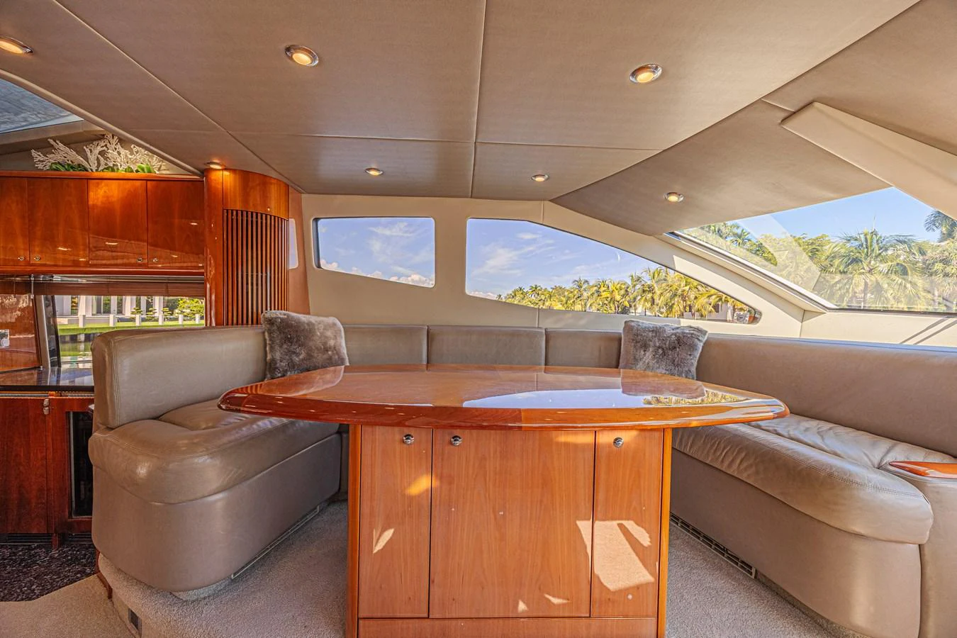 The yacht's salon features a cozy seating area with a polished wooden table and large windows offering scenic views. aboard BIG CHUBBY XL Yacht for Sale