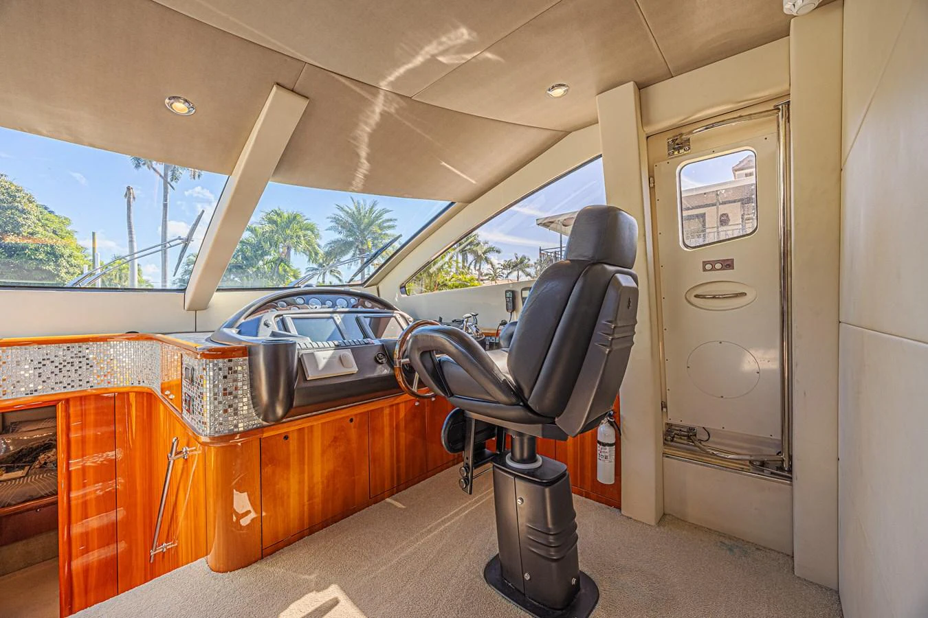 The helm station features a sleek design with a comfortable captain's chair and advanced navigation equipment. aboard BIG CHUBBY XL Yacht for Sale
