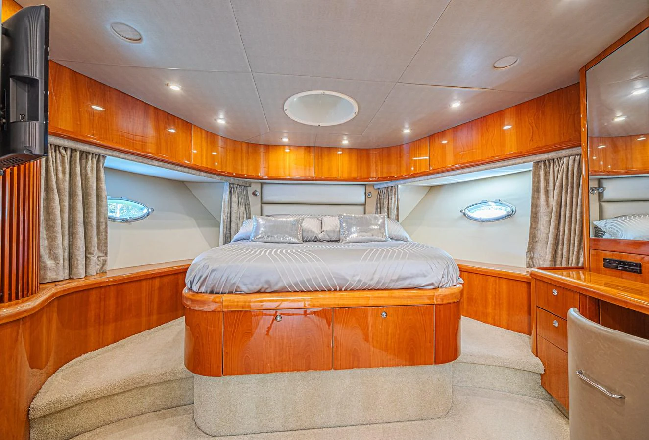 The master stateroom features a luxurious bed with elegant wood paneling and ample natural light. aboard BIG CHUBBY XL Yacht for Sale
