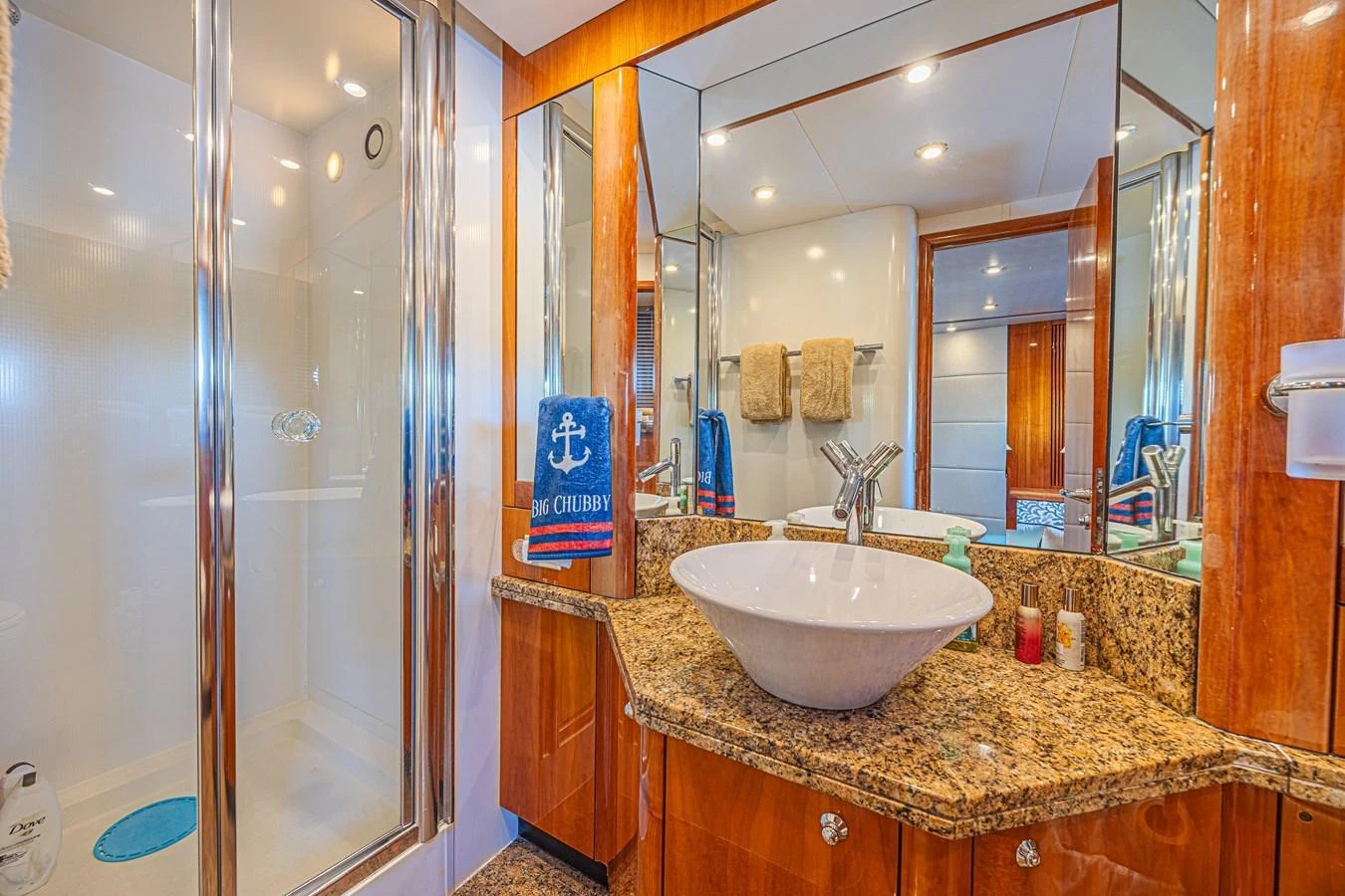 The yacht's bathroom features a modern sink, granite countertop, and a spacious shower area. aboard BIG CHUBBY XL Yacht for Sale