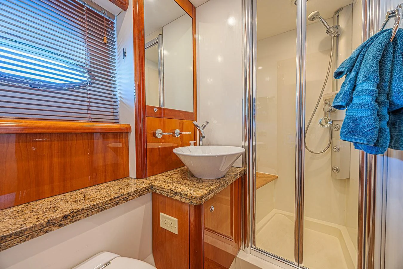 A well-appointed yacht bathroom featuring a modern sink and a glass-enclosed shower. aboard BIG CHUBBY XL Yacht for Sale