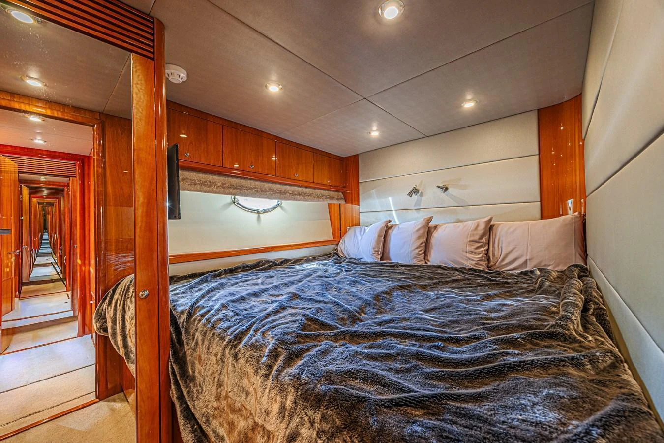 The stateroom features a luxurious bed with plush bedding and warm wooden accents. aboard BIG CHUBBY XL Yacht for Sale