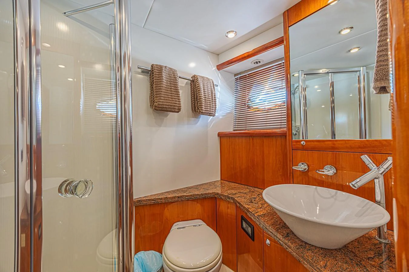 The yacht's bathroom features a modern sink, wooden cabinetry, and a glass-enclosed shower. aboard BIG CHUBBY XL Yacht for Sale