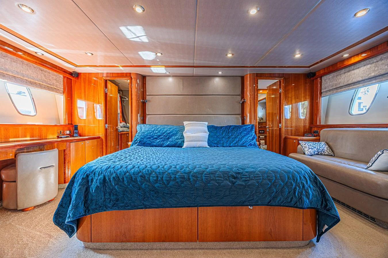 The master stateroom features a spacious bed with elegant wood paneling and ample natural light. aboard BIG CHUBBY XL Yacht for Sale
