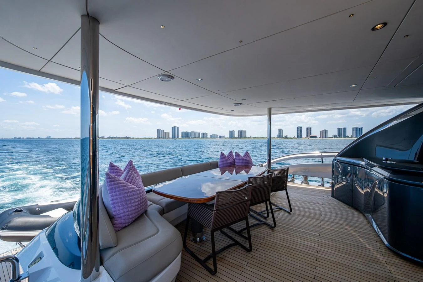 a deck with a table and chairs on it aboard SPLASH Yacht for Sale