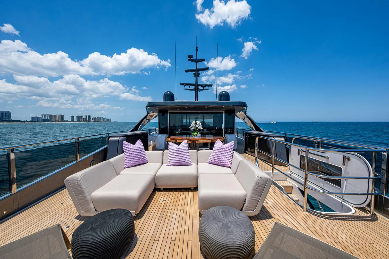 a deck with a view of the ocean and a large ship aboard SPLASH Yacht for Sale