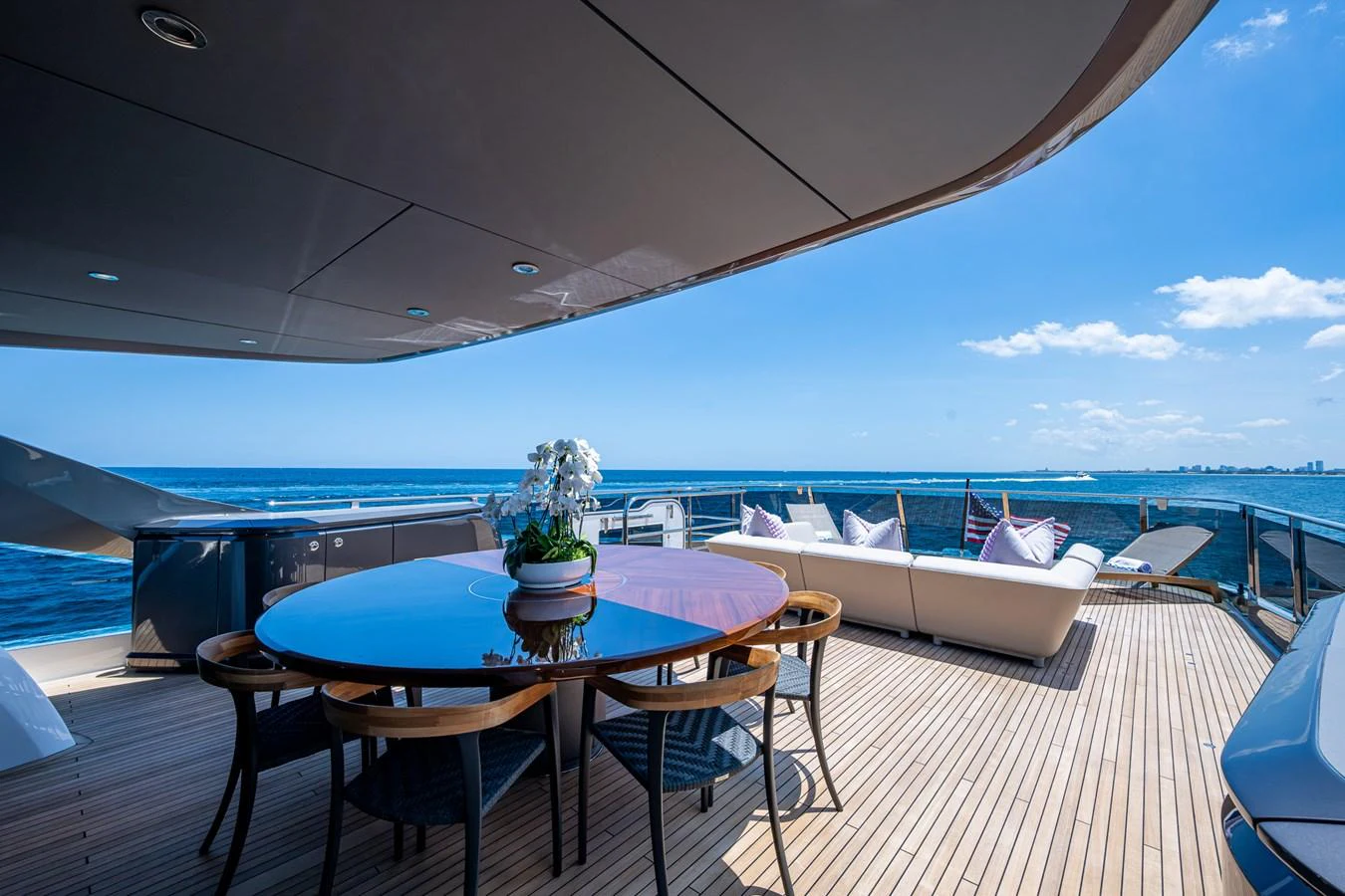 a table and chairs on a deck overlooking a large body of water aboard SPLASH Yacht for Sale