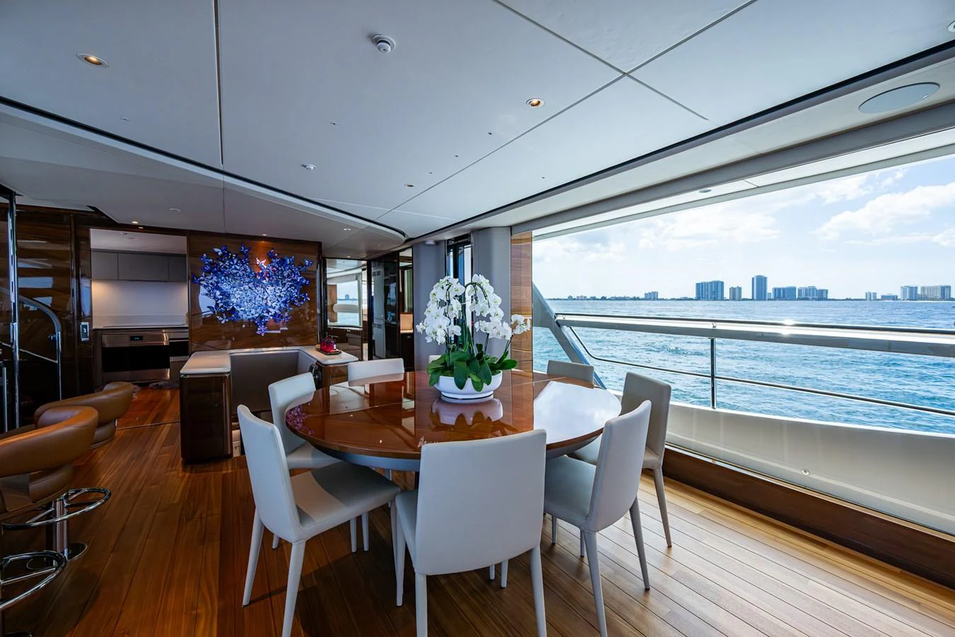 a dining table in a room with a large window overlooking a city aboard SPLASH Yacht for Sale