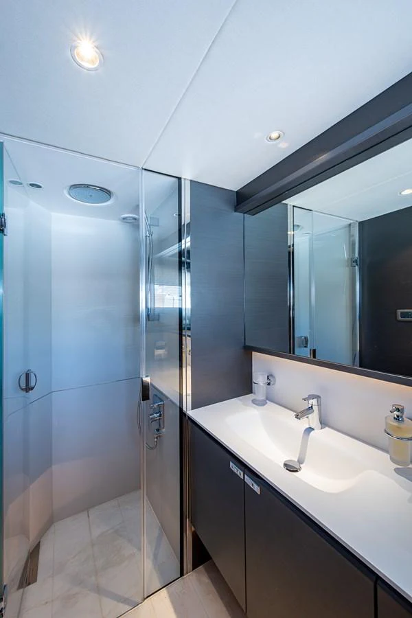a bathroom with a shower and sinks aboard SPLASH Yacht for Sale