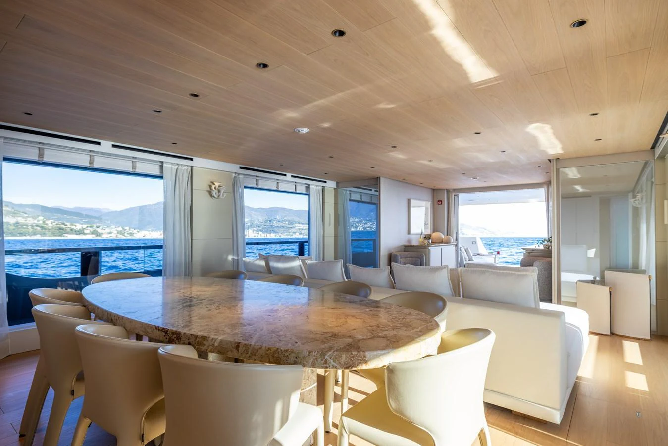 a large living room with a large table and chairs aboard STELLAMAR Yacht for Sale
