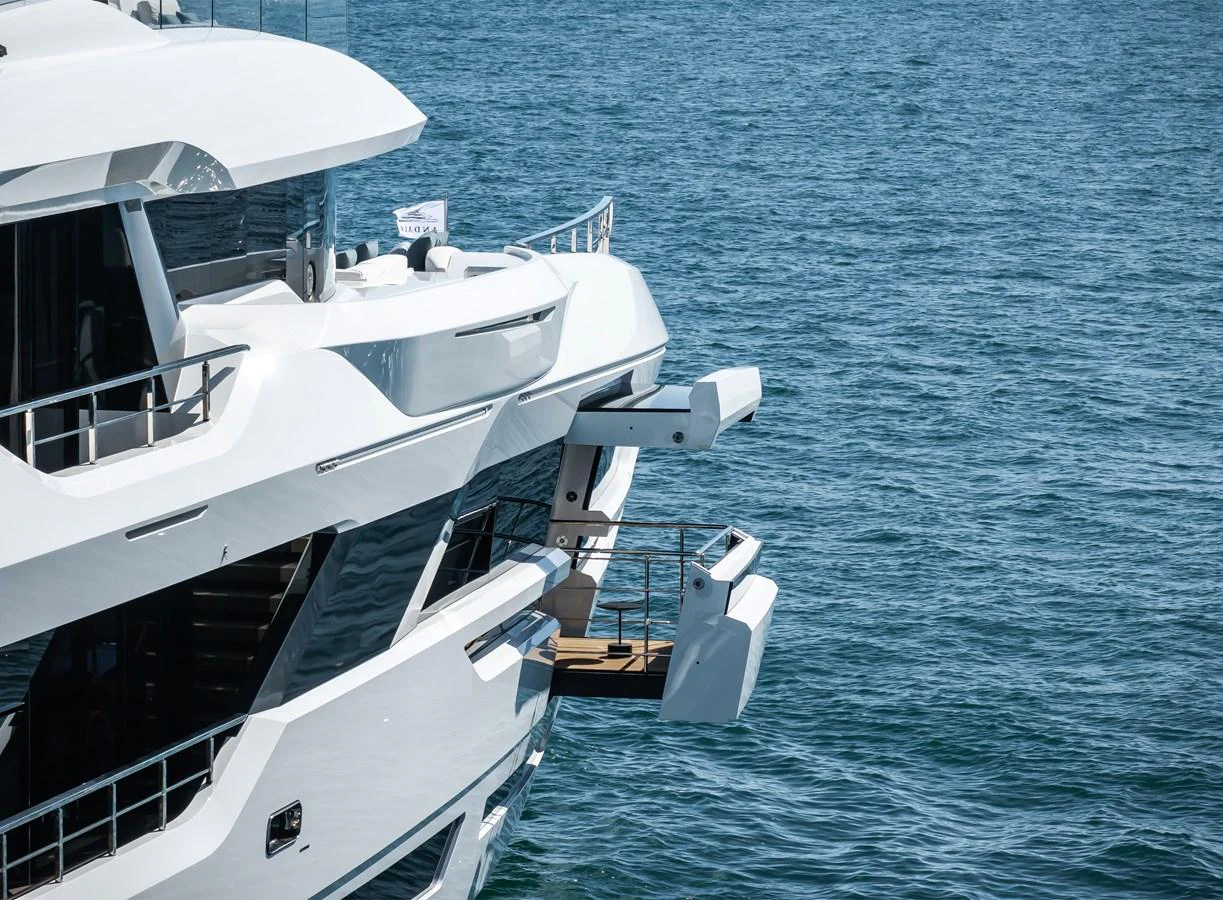 The yacht features a sleek, modern exterior with a fold-out balcony over the water. aboard ANDALA Yacht for Sale