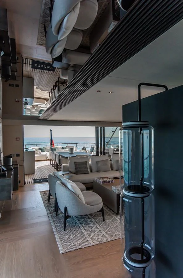 The yacht's salon features modern furnishings and an open layout with a view of the aft deck. aboard ANDALA Yacht for Sale