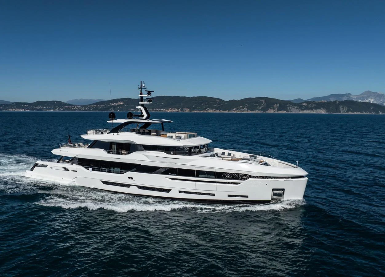 A sleek and modern yacht cruising on the open sea under a clear blue sky. aboard ANDALA Yacht for Sale
