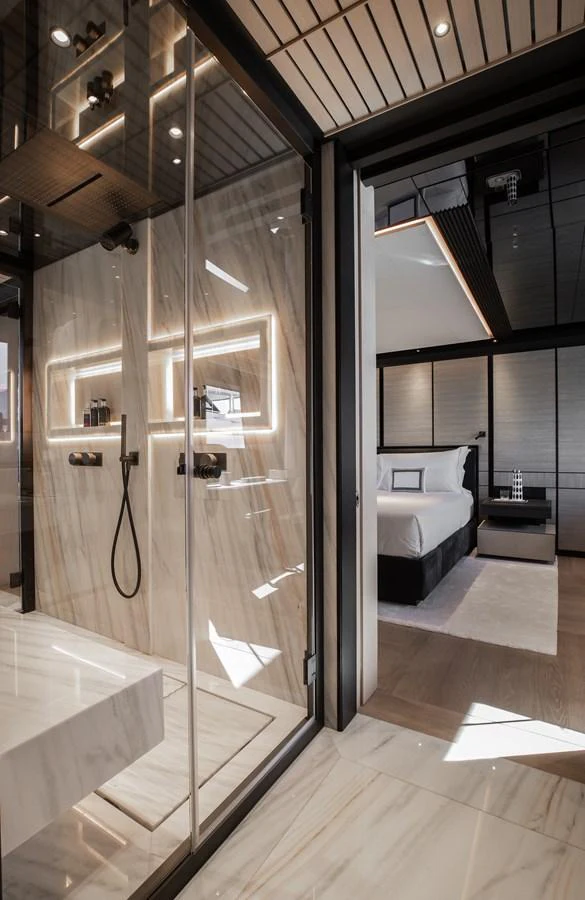 The luxurious master stateroom features a sleek, modern design with a spacious shower area and elegant lighting. aboard ANDALA Yacht for Sale