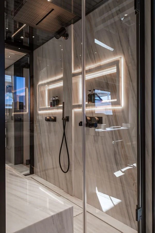 The yacht's bathroom features a sleek, modern design with luxurious marble walls and ambient lighting. aboard ANDALA Yacht for Sale