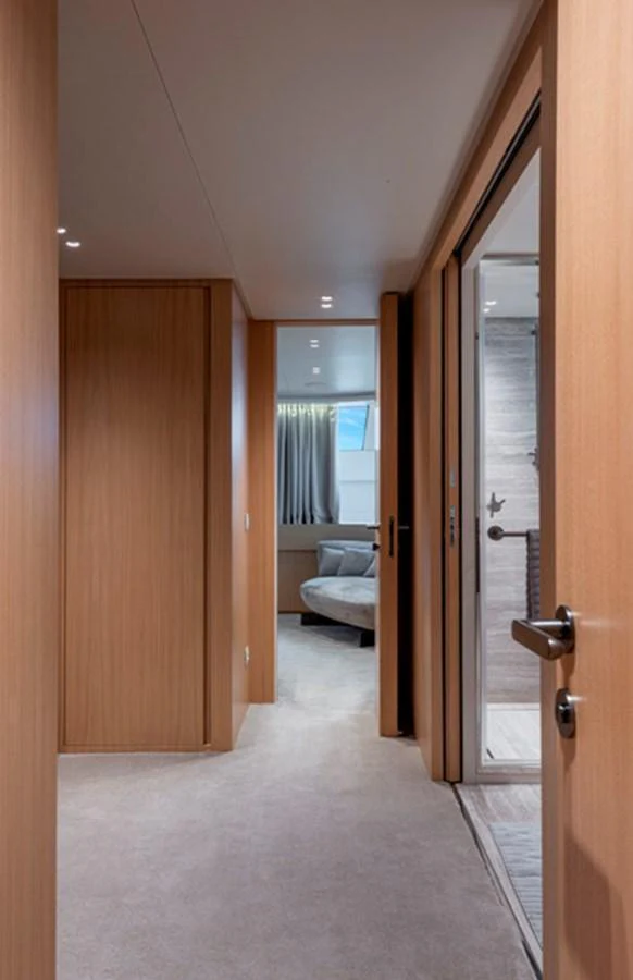 A sleek hallway with wooden paneling leads to a cozy seating area on a luxurious yacht. aboard FATSA Yacht for Sale