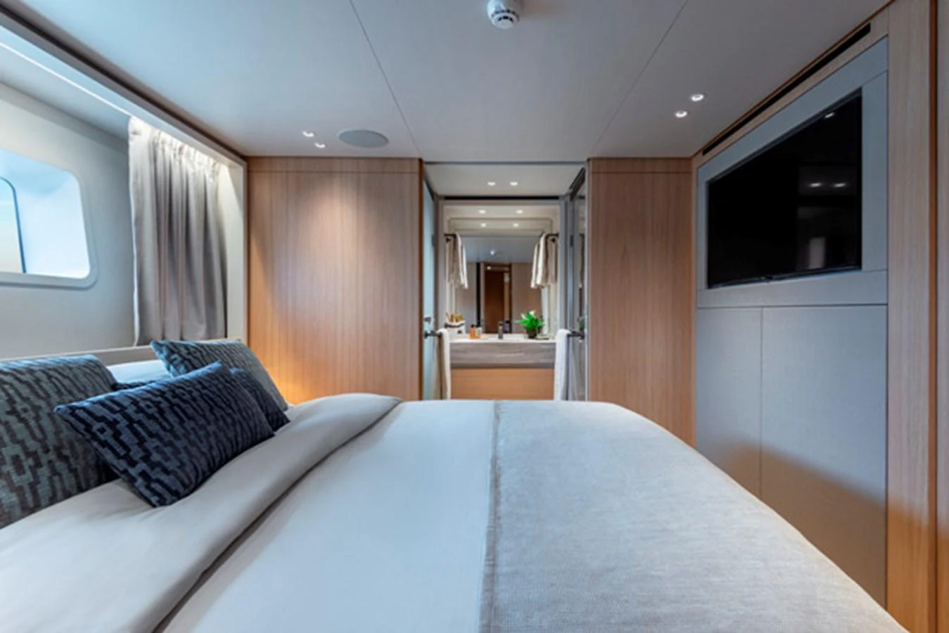 The stateroom features a plush bed, elegant wood paneling, and a modern entertainment system. aboard FATSA Yacht for Sale