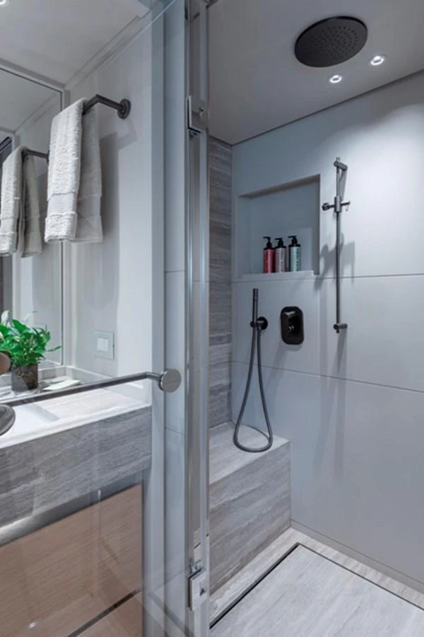 The yacht's bathroom features a modern shower area with sleek fixtures and elegant finishes. aboard FATSA Yacht for Sale