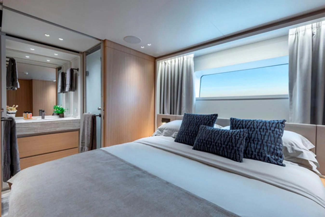 A luxurious stateroom featuring a large bed, elegant decor, and ample natural light. aboard FATSA Yacht for Sale