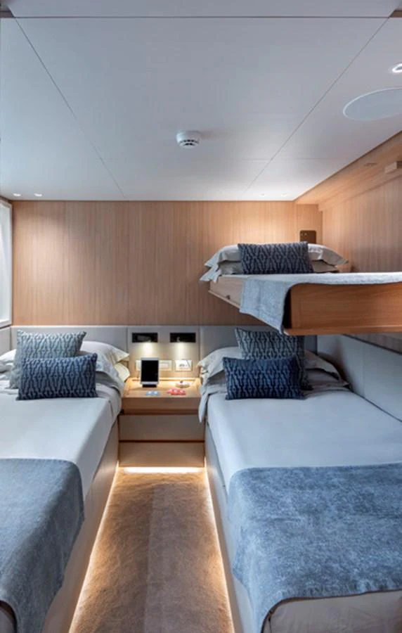 The guest stateroom features twin beds with a modern, cozy design and soft lighting. aboard FATSA Yacht for Sale