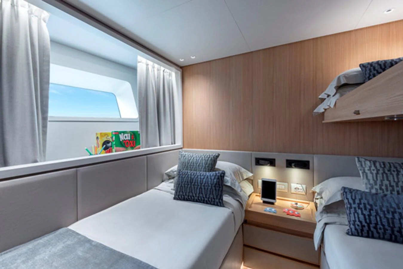 A cozy guest stateroom featuring twin beds, modern decor, and a large window for natural light. aboard FATSA Yacht for Sale