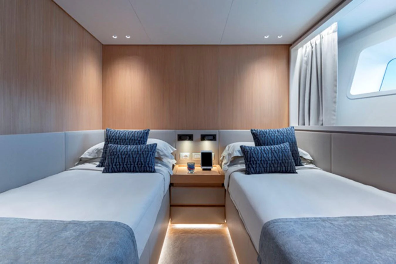 The guest stateroom features twin beds with elegant bedding and soft lighting, creating a cozy and inviting atmosphere. aboard FATSA Yacht for Sale